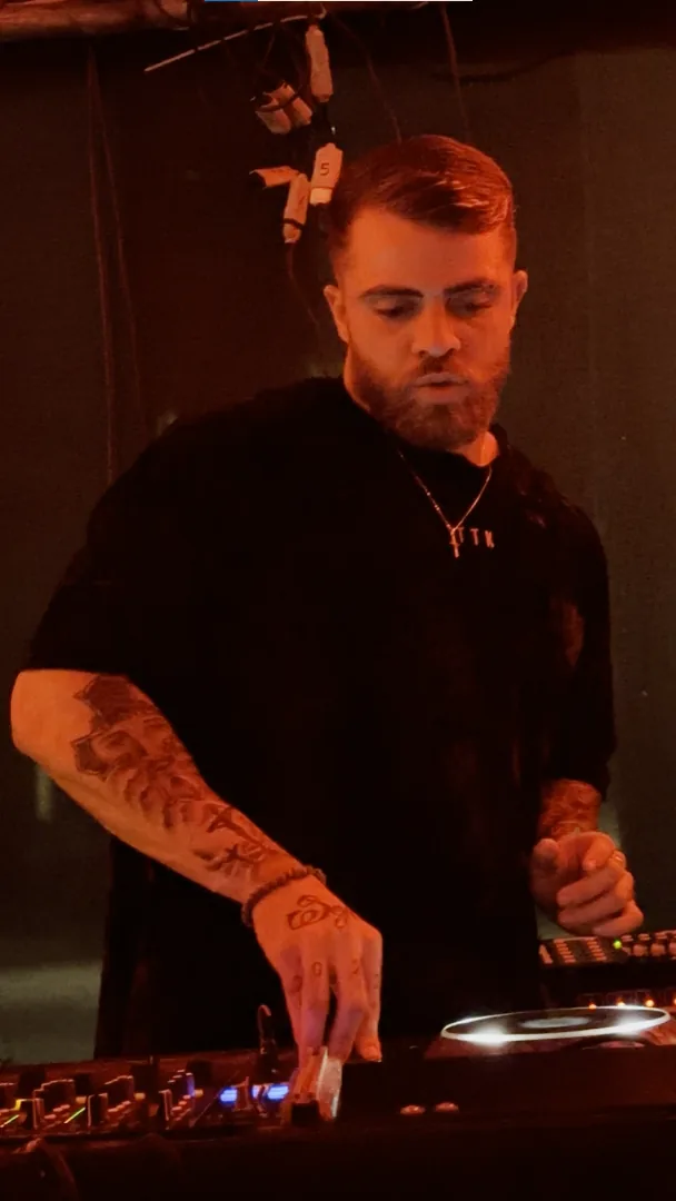 Sttef tocando em um evento menor com iluminação vermelha