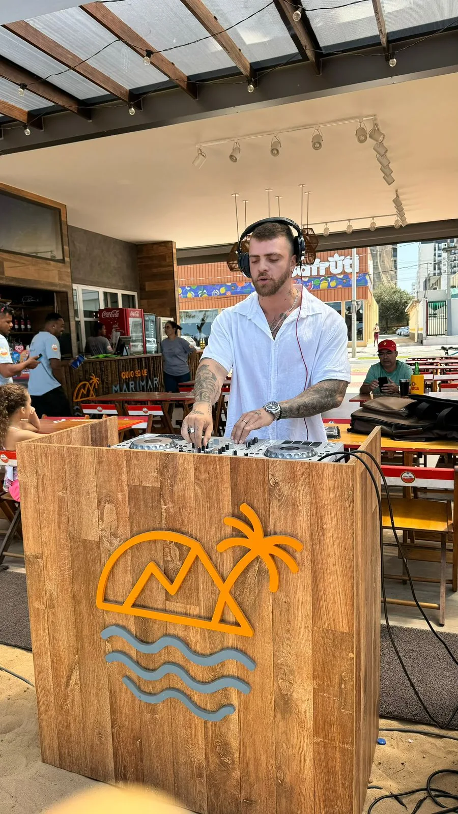 Sttef tocando em um evento pequeno e diurno, próximo ao público